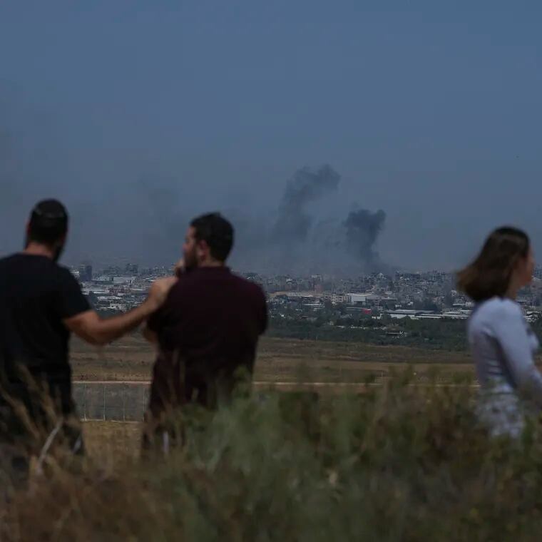 People watch smoke rising to the sky after an explosion in the Gaza Strip, as seen from southern Israel.