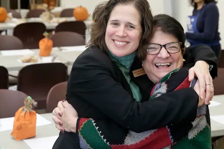 Cathedral Kitchen incoming executive director Carrie Kitchen-Santiago (left) and outgoing executive director Karen Talarico share a hug in the East Camden dining room of the respected nonprofit.  ELIZABETH ROBERTSON / Staff Photographer
