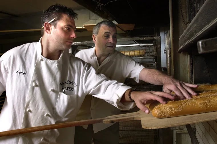 At Sarcone's Bakery, Louis Sr. and Louis Jr. test the bread for doneness as they take the loaves out of the huge brick oven in 2001.