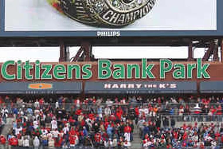 Fans turn toward the giant video screen in left field at Citizens Bank Park to viewan image of the Phillies' diamond-studded World Series ring.