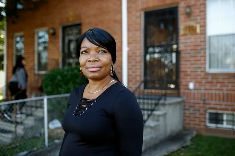 Octavia Mason poses for a photo outside of her mother's home in Baltimore. Mason's drug use after a broken marriage caused her to lose her license to teach high schoolers to become pharmacy technicians. Now she participates in a program called "Turnaround Tuesday" that helps people with criminal records, struggles with drug addiction, or simply a life of poverty find a living wage job.