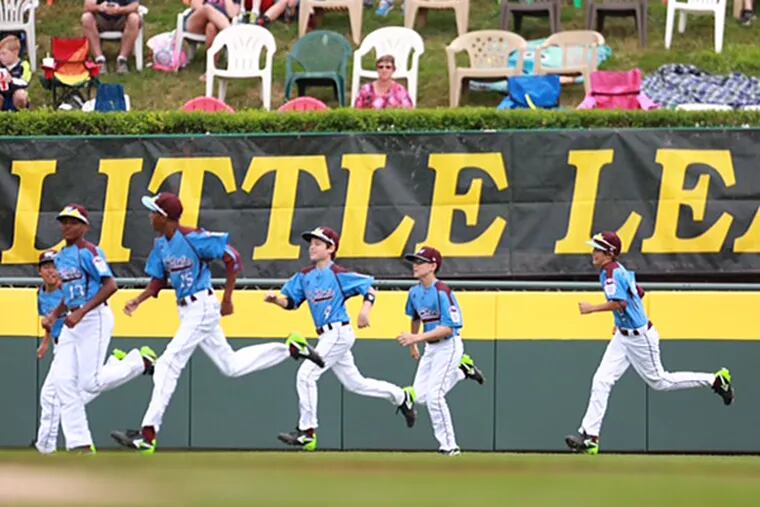 Taney players run onto the field in Williamsport, Pa. before their first game of the 2014 Little League World Series. (David Swanson/Staff Photographer)