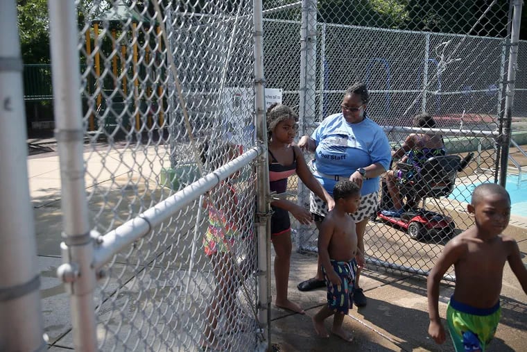 Pool maintenance attendant Jeneen Helms, rear, allows kids back into the pool at the Baker Playground pool in West Philadelphia on Saturday, July 20, 2019. Helms was working when seven people were shot at the playground during a cookout July 13.