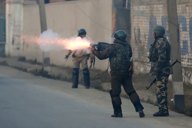 An Indian paramilitary soldier fires tear gas shells on Kashmiri protesters during a clash in Srinagar, Indian controlled Kashmir, Saturday, Dec. 15, 2018. At least seven civilians were killed and nearly two dozens injured when government forces fired at anti-India protesters in disputed Kashmir following a gunbattle that left three rebels and a soldier dead on Saturday, police and residents said. (AP Photo/Mukhtar Khan)