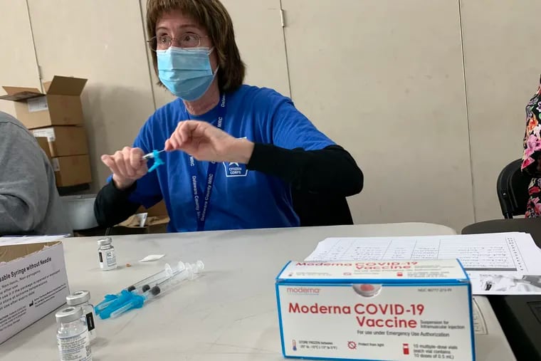 Nurse Louise Enderle draws Moderna COVID-19 vaccine into a syringe at a pop-up mass vaccination site at Upper Darby High School on March 14, 2021.