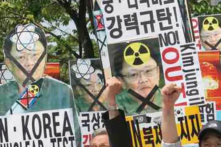 South Koreans carrying defaced pictures of North Korean leaderKim Jong Il join in a rally yesterday near the U.S. Embassy in Seoul.