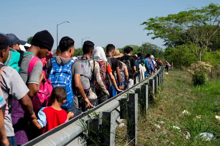 Central American migrants, part of a caravan hoping to reach the U.S. border, walk on the shoulder of a road in Frontera Hidalgo, Mexico, Friday, April 12, 2019. The group pushed past police guarding the bridge and joined a larger group of about 2,000 migrants who are walking toward Tapachula, the latest caravan to enter Mexico.