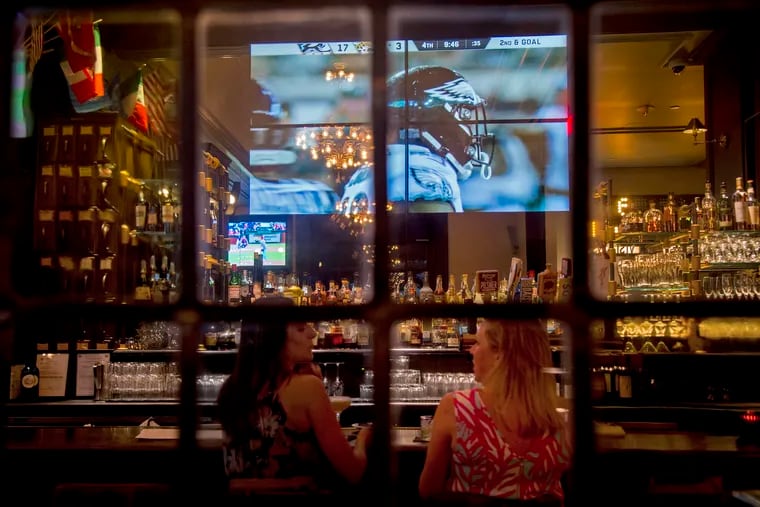 Brittany Wardzinski (left) and Sara Cunningham (right) have a drink at P.J. Clarke's at the Curtis, 6th & Walnut Streets, in August 2019. P.J. Clarke's plans to reopen.