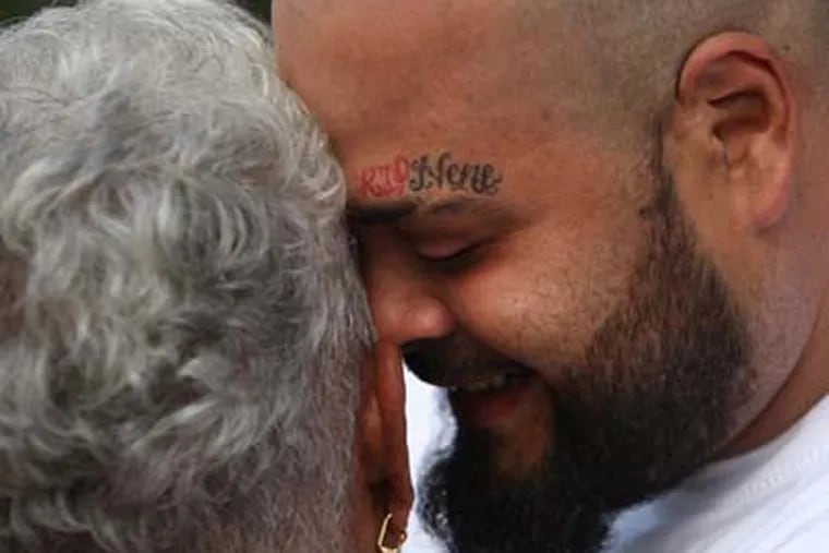 Jose Gonzalez hugs Doris Malevet before the beginning of the Vigil and march.  Jose's brother Louis "Nene" Gonzalez was a victim, and Doris daughter Mita was also a victim. Vigil for Non Violence outside the home of Doris Malevet, mother of Mita Reyes at 830 N. 6th Street,Camden,NJ.   ( RON CORTES / Staff Photographer ).