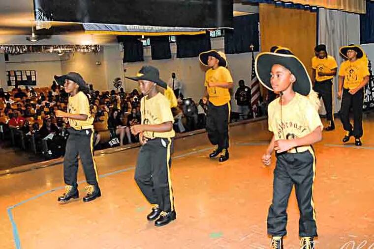 Gold Coast Funkerterrs marching at school assembly. It's swan song time for the young members of the Gold Coast Buccaneers, a drill team that had been coached by Gregory Scott, killed in front of his West Philly home earlier this year. The drill team members are graduating, the last batch of kids Scott coached. They are performing at Huey Elementary, also set to close. ( Special to the Inquirer / Dawan "bambi"Savage )