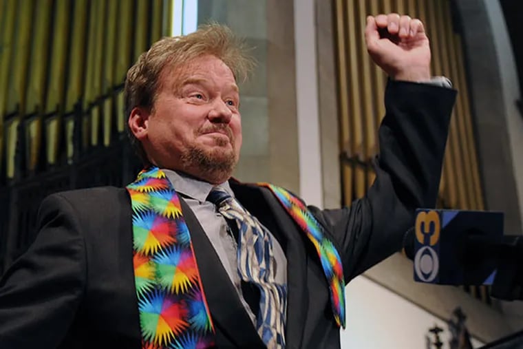 Defrocked United Methodist minister Frank Schaefer, wearing a rainbow stole for solidarity with LGBT people, does a little dance in celebration at a press conference where he announced the church had reinstated his credentials June 24, 2014. ( CLEM MURRAY / Staff Photographer )