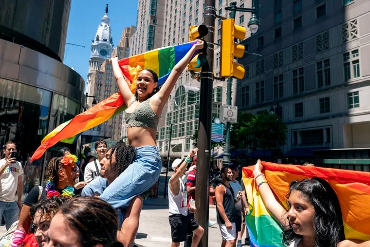 Kimberly Orozco rides on the shoulders of Keven Collins on Market Street headed to the Pride festival in the Gayborhood with entertainment, food and games.