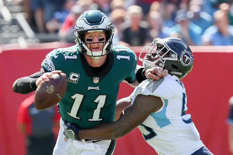 Eagles quarterback Carson Wentz, left, cannot escape the grasp of Titan linebacker Jayon Brown, right, in the forst quarter of Sunday's game. Eagles lost to the Tennessee Titans at Nashville on Sunday September 30, 2018, 26-23 in overtime. MICHAEL BRYANT / Staff Photographer