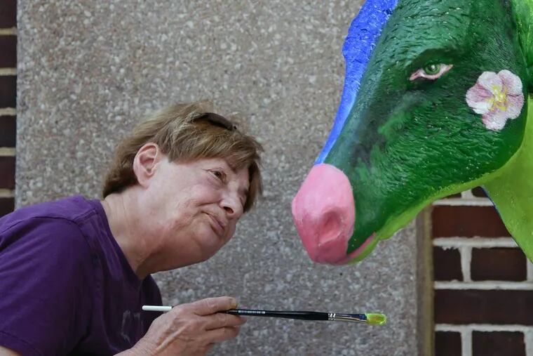 Barbara Sosson touching up "Iowa," one of the 57 fiberglass "Donkeys Around Town" DNC installation.