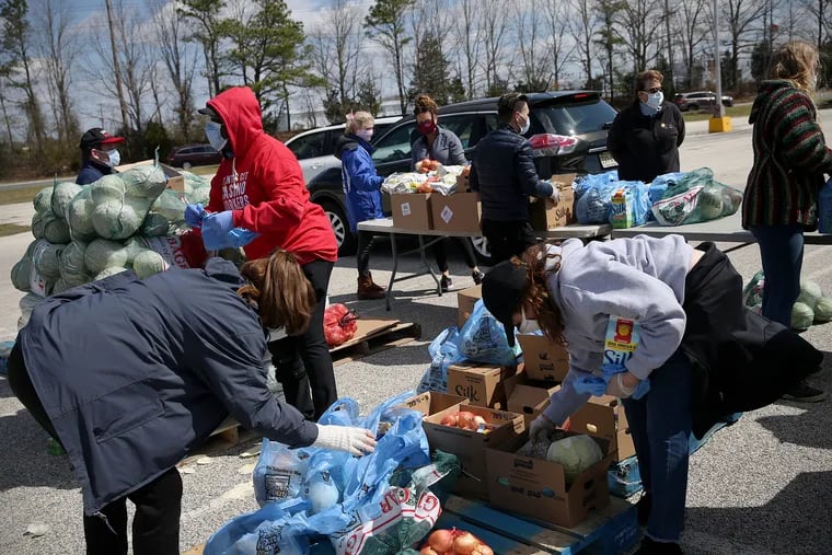 Casino workers and food bank volunteers package up items during a food distribution for casino workers at Harbor Square in Egg Harbor Township on Wednesday.