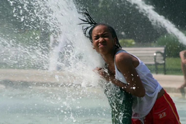 Alaya Freeman, 10, cools off yesterday in Swann Fountain at Logan Square.