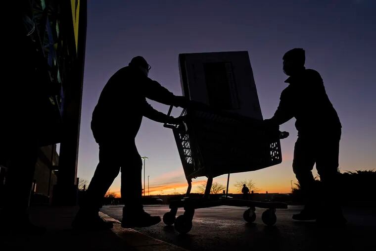 People transport a television to their car after shopping during a Black Friday sale at a Best Buy store last month in Overland Park, Kan.