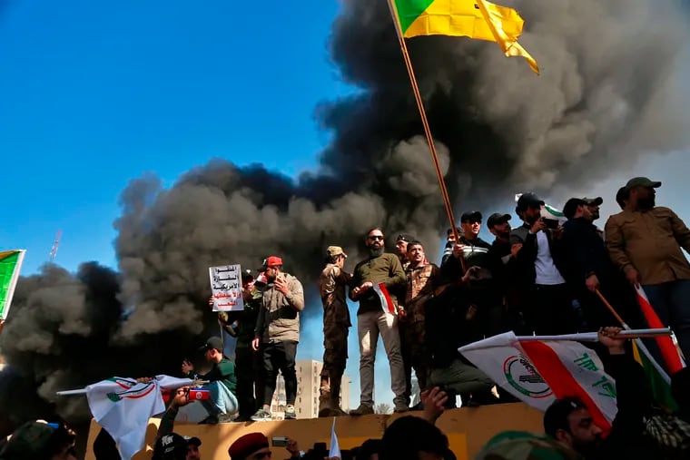 Protesters burn property in front of the U.S. embassy compound, in Baghdad, Iraq, Tuesday, Dec. 31, 2019. Dozens of angry Iraqi Shiite militia supporters broke into the U.S. Embassy compound in Baghdad on Tuesday after smashing a main door and setting fire to a reception area, prompting tear gas and sounds of gunfire.
