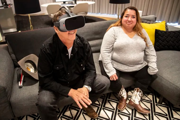 James Baldwin demonstrates how to use a pair of NuEyes, as his wife, Claudia Baldwin, sits nearby at Comcast's Accessibility Lab in the Comcast Technology Center in Philadelphia.