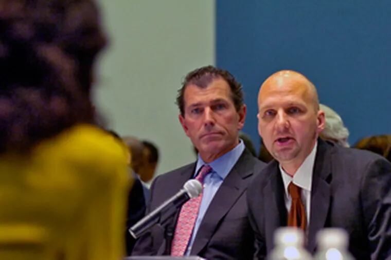 Todd McIntire (right), general manager of Edison Schools Inc., answers a questionat the hearing as John Chubb, Edison&#0039;s chief educational officer, listens.