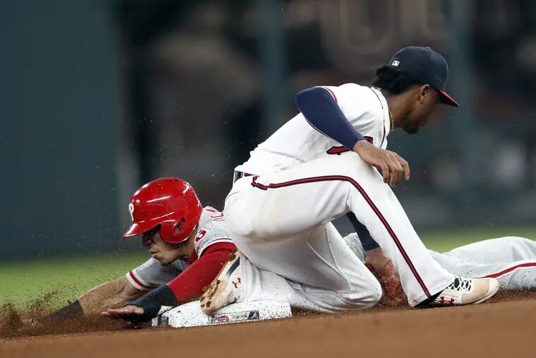 Phillies infielder Cesar Hernandez is tagged out by Braves infielder Ozzie Albies on Thursday.