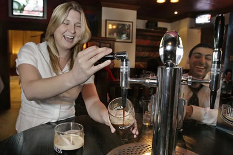 Frances Bevan of Phila. pours her own beer, during happy hour, at Tir na Nog the pub inside the Phoenix at 16th and Arch St. in Phila. on June 9, 2010 ( Elizabeth Robertson / Staff Photographer )