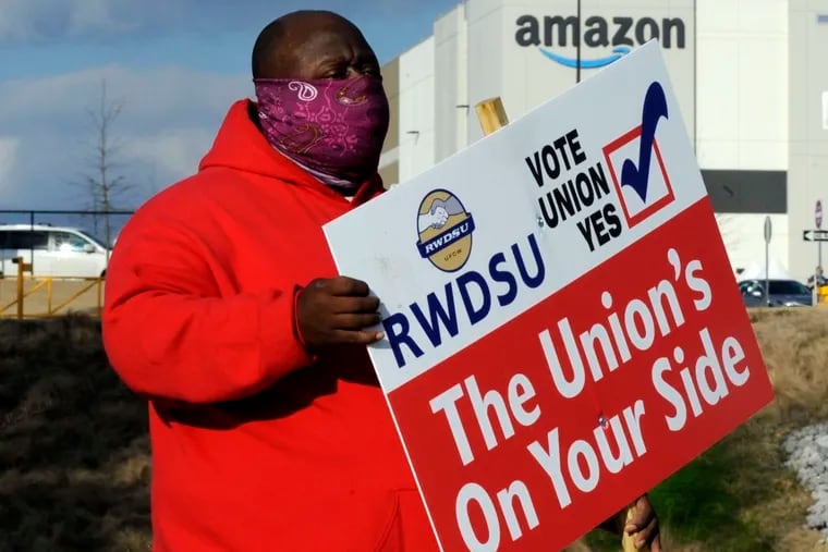 Michael Foster of the Retail, Wholesale and Department Store Union holds a sign outside an Amazon facility where labor is trying to organize workers. President Joe Biden said workers in Alabama and across the country have the right to join a union without intimidation from their companies. His comments come as Amazon workers in the state are voting on whether they should unionize.