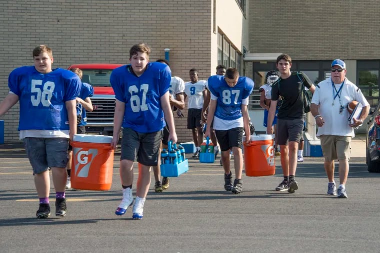 August can be a deadly month for football players. Conwell-Egan Catholic High School football coach Jack Techtmann (right), makes sure his players take precautions including numerous water breaks, to prevent any heat-related incidents. (CLEM MURRAY / For the Inquirer )