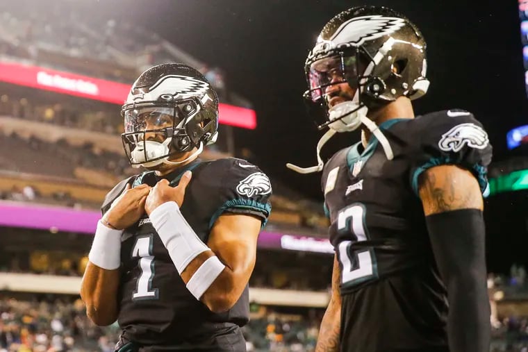 Eagles quarterback Jalen Hurts (1) and cornerback Darius Slay before a game against the Green Bay Packers at Lincoln Financial Field in November 2022.