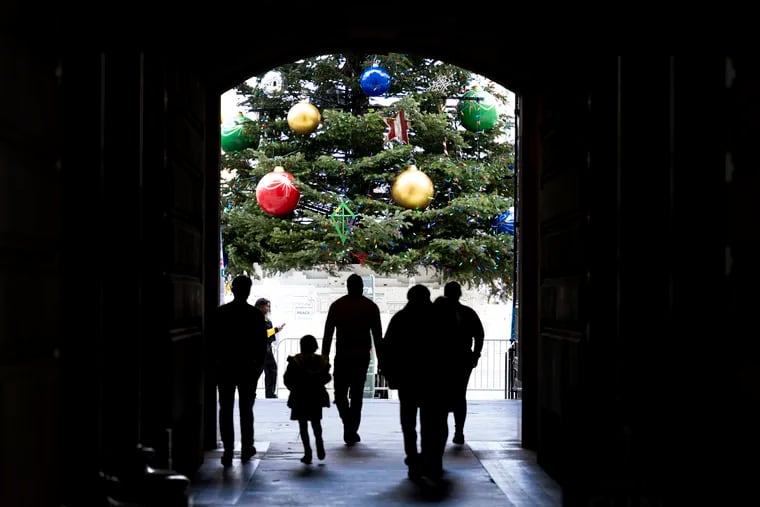 Pedestrians walked through the halls of City Hall approaching a 55-feet tall Christmas tree in Philadelphia on Monday.