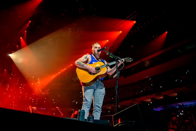 Country star Zach Bryan, wearing a Sixers jersey, performs Tuesday in the first of two concerts at the Wells Fargo Center.