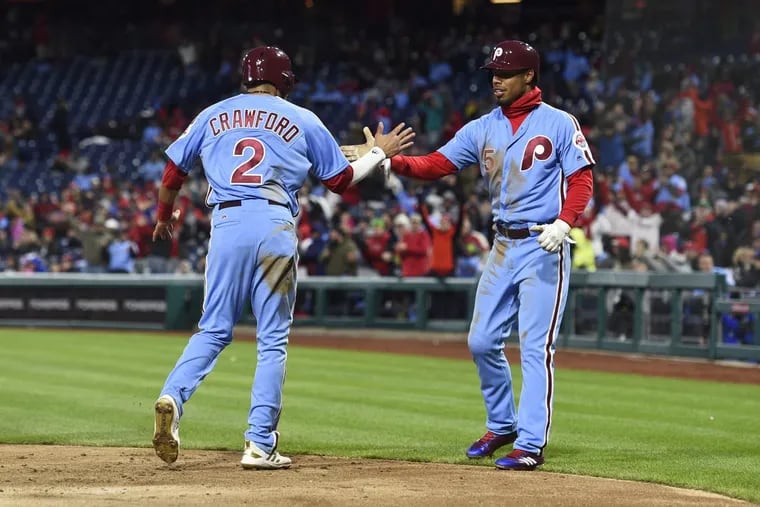 Phillies outfielder Nick Williams (right) celebrates with shortstop J.P. Crawford after Cesar Hernandez’s three-run single against the Pirates on Thursday.