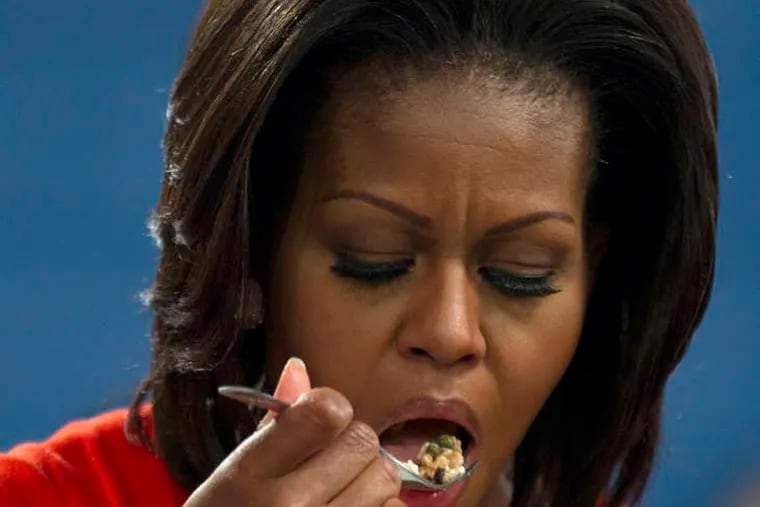 Michelle Obama eats food cooked by students duringa "Let's Move" event at a Dallas recreation center.