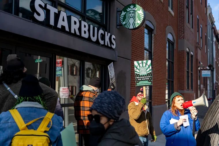 A Member of Philly Socialists leads chants as Starbucks Workers Union members are striking outside during Starbucks Red Cup Day at South Street and 22nd Street in Philadelphia, Pa., on Thursday Nov. 17, 2022.