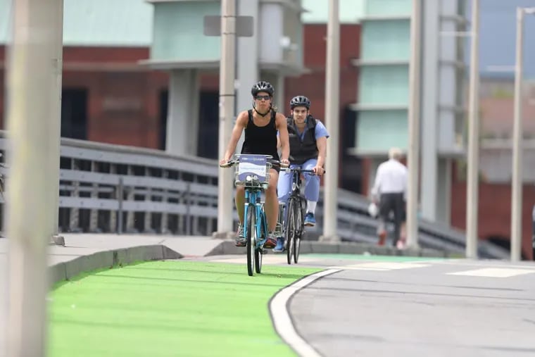 Cyclists use a green bike lane on South Street near 27th Street heading east. ( DAVID SWANSON / Staff Photographer )