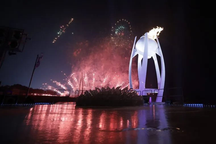 Fireworks explode behind the Olympic flame during the opening ceremony of the 2018 Winter Olympics in Pyeongchang, South Korea, Friday, Feb. 9, 2018.