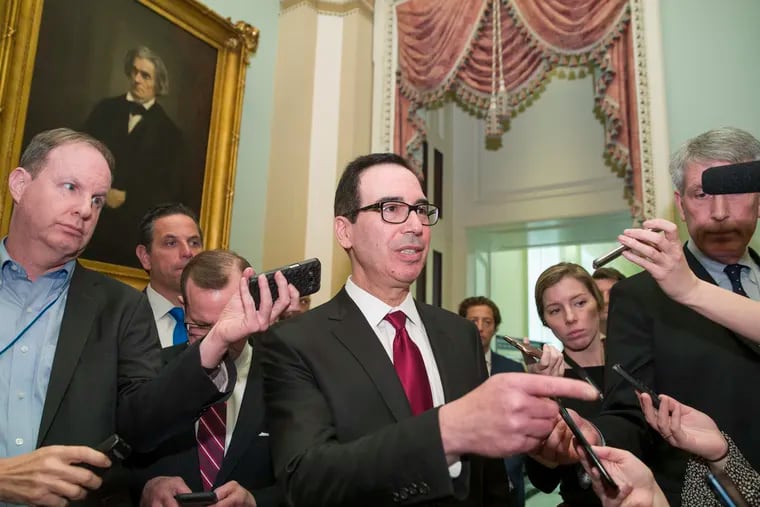 Treasury Secretary Steve Mnuchin, center, speaks with reporters as he departs the Republican policy luncheon on Capitol Hill, Tuesday, Jan. 15, 2019 in Washington.