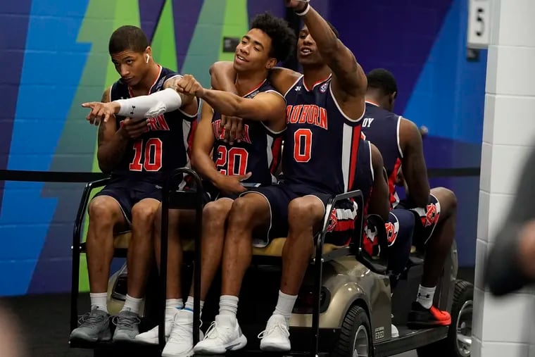 Auburn's Samir Doughty (10), Myles Parker (20) and Horace Spencer (0) get a ride after a practice session for the semifinals of the Final Four NCAA college basketball tournament, Thursday, April 4, 2019, in Minneapolis. (AP Photo/David J. Phillip)
