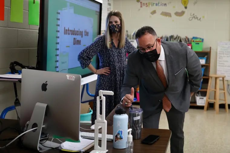 U.S. Secretary of Education Miguel Cardona (right) talks to students who are learning online while visiting teacher Meghan Horleman’s second grade classroom at Olney Elementary in Philadelphia.