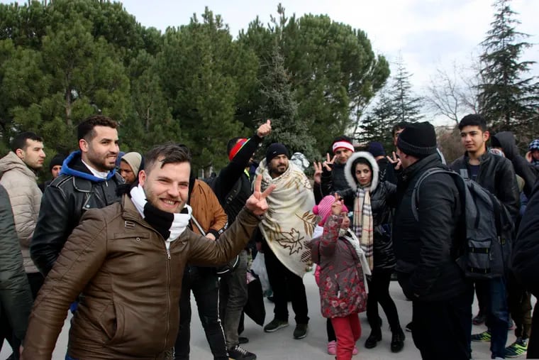 Migrants react as they walk to the border gate of Pazarkule in Edirne, near Turkey-Greece border, early Friday, Feb. 28, 2020. An air strike by Syrian government forces killed scores of Turkish soldiers in northeast Syria, a Turkish official said Friday, marking the largest death toll for Turkey in a single day since it first intervened in Syria in 2016.