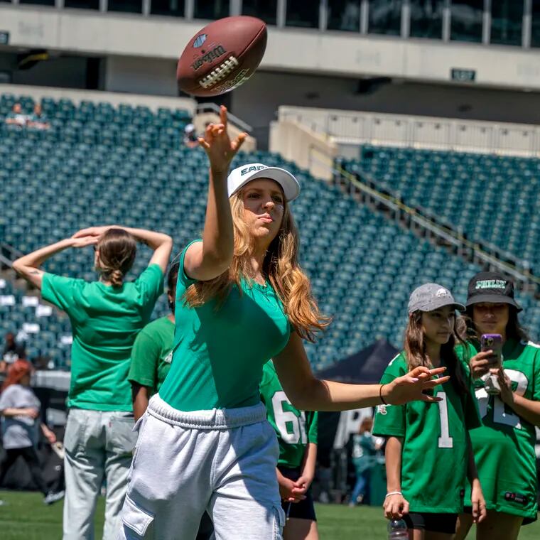 Sadie Doyle, 16, from Flemington, N.J., tosses a football on the field at the Linc during the Eagles' Women’s Football Festival on Sunday. She was there with her sister, Piper, 17.