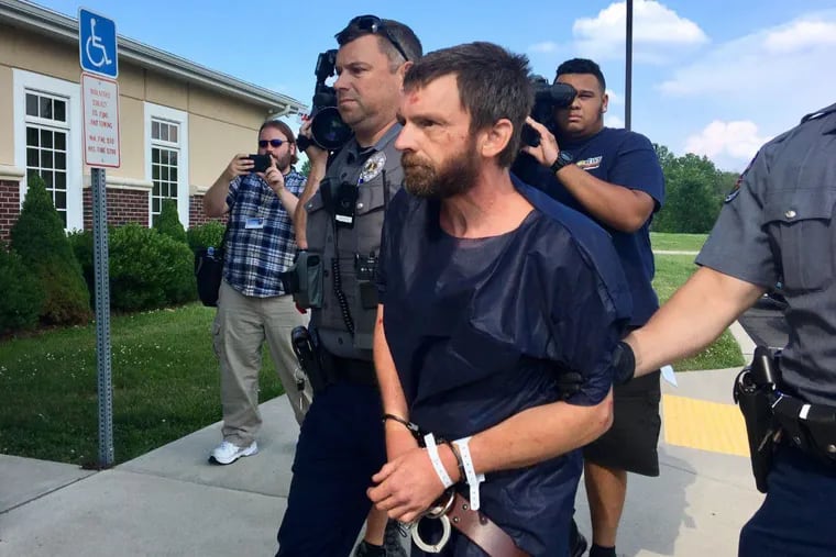 Stephen Deatelhauser, 45, of Souderton is walked into District Court in Quakertown on July 5, hours after authorities said he stabbed Lansdale patrolman Daniel Gallagher on Route 309 in Richland.