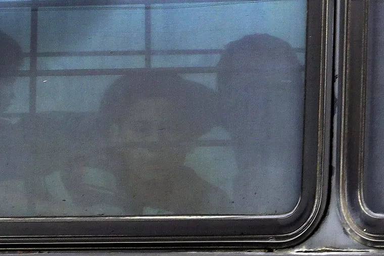 A boy stares out of a heavily tinted bus window leaving a U.S. Customs and Border Protection facility, Tuesday, June 19, 2018, in McAllen, Texas.
