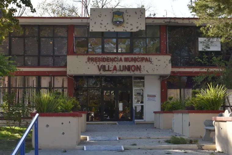The City Hall of Villa Union is riddled with bullet holes after a gun battle between Mexican security forces and suspected cartel gunmen, Saturday, Nov. 30, 2019. At least 14 people were killed, four of them police officers, after an armed group in a convoy of trucks stormed the town, in Coahuila state, prompting security forces to intervene, state Gov. Miguel Riquelme Solis said. (AP Photo/Gerardo Sanchez)