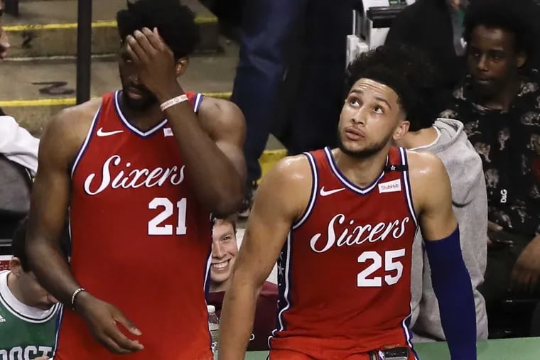 Sixers center Joel Embiid and guard Ben Simmons watch the end of game one against the Boston Celtics during the Eastern Conference semifinals on Monday, April 30, 2018 in Boston.  The Celtics beat the Sixers 117-101.
