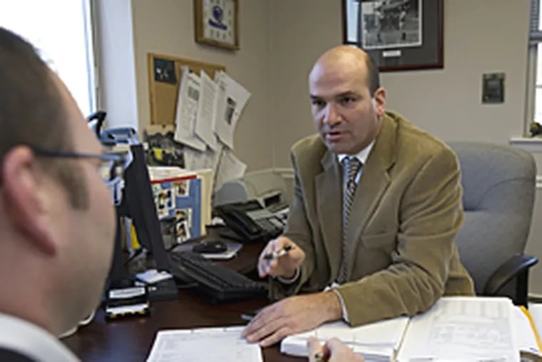 With low interest rates, folks are flocking to mortgage brokers. Here, broker Jerome Scarpello, right, talks to client Michael Beachkofsky. (Ed Hille / Inquirer)