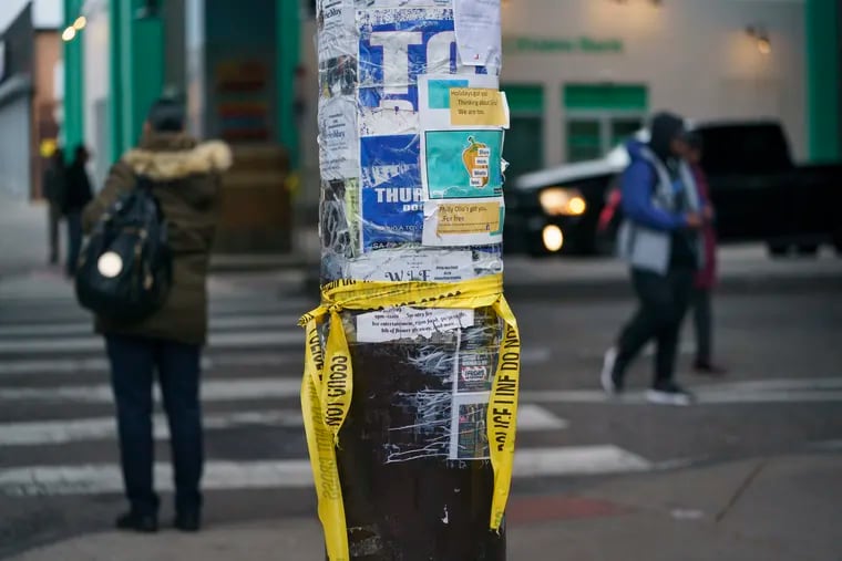 Crime scene tape at the intersection at 52nd and Market Streets in West Philadelphia where three men were wounded in a shooting early Wednesday.