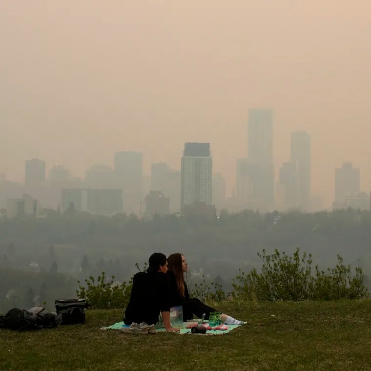 Smoke from wildfires blankets the city as a couple has a picnic in Edmonton, Alberta, on Saturday.