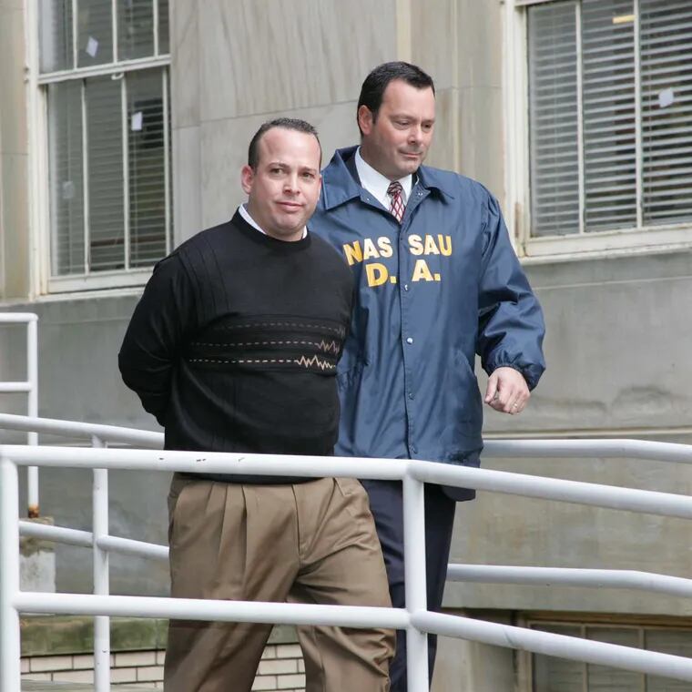 In this 2005 file photo, Joseph W. LaForte is escorted out of police headquarters in Mineola, N.Y. after being charged with running a $12 million money laundering ring.