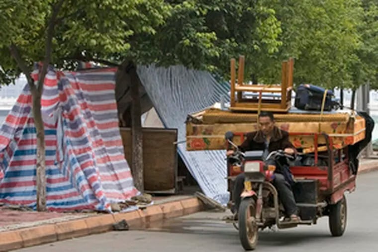 Evacuees in China brought their belongings back closer to home after being allowed to return yesterday. They had been displaced by a lake formed by the May earthquake.